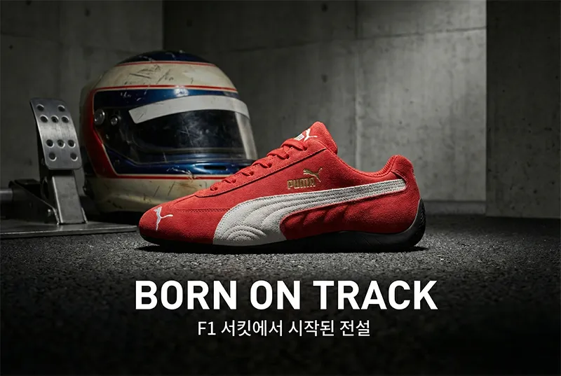 F1 레이싱 헬멧과 아스팔트 질감 위에 놓인 푸마 스피드캣 OG 스니커즈
