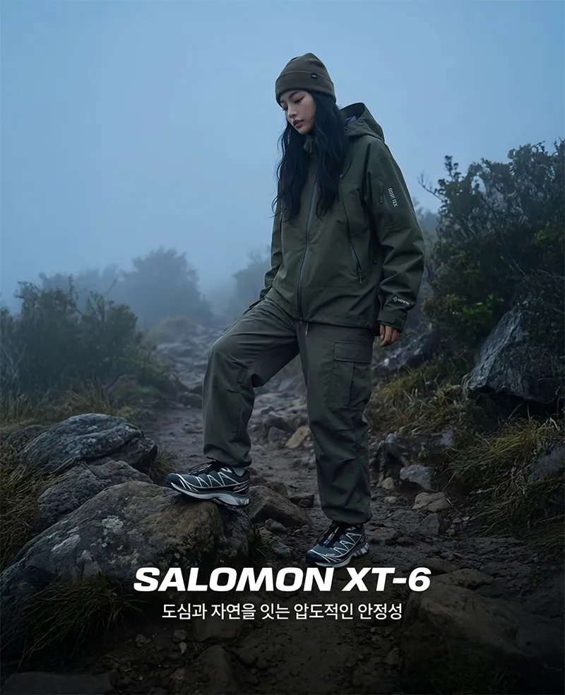 살로몬 XT-6를 착용하고 거친 돌길 위에 서 있는 고프코어 스타일링의 전신 샷